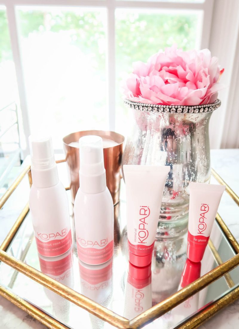 Kopari Beauty Products on Glass Table with Flowers